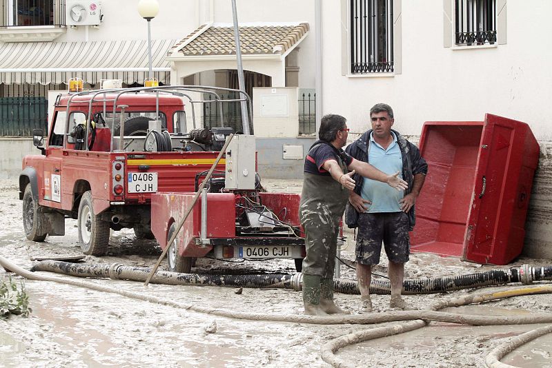 Bomberos y vecinos trabajan en las labores de limpieza en la localidad de Aguilar de la Frontera.