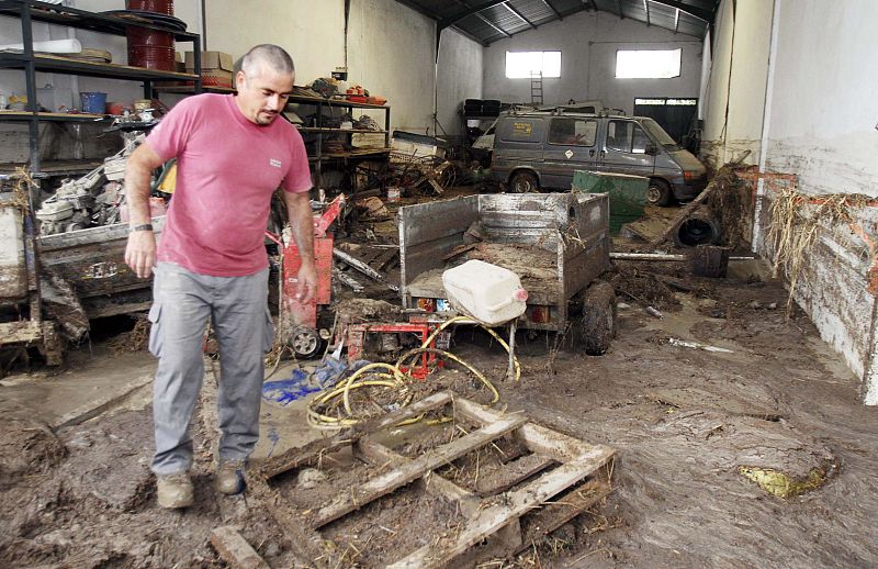 Un hombre observa el estado en el que ha quedado una nave de la localidad de Aguilar de la Frontera.