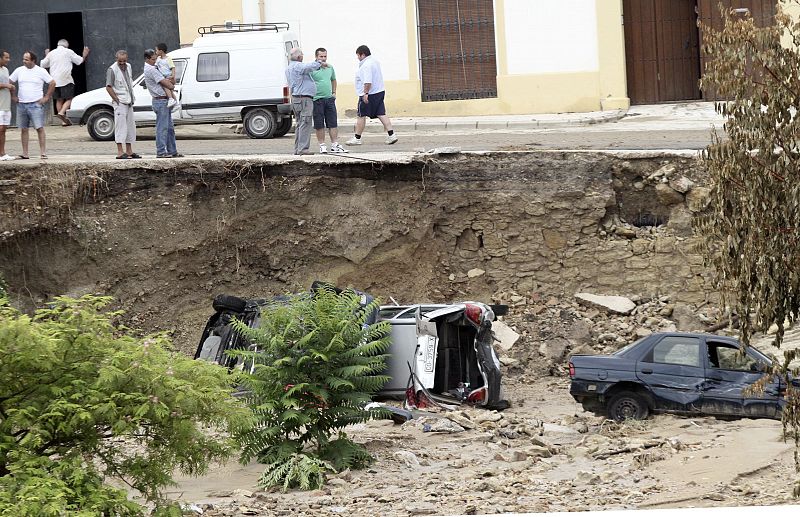 Vecinos de la localidad de Aguilar de la Frontera observan el estado en el que ha quedado varios coches.