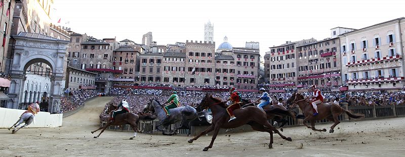 A jockey from Montone parish (L) leads the pack of riders during a training session of the Palio race in Siena