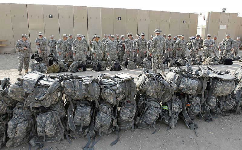 U.S. soldiers of the 1st Battalion, 116th Infantry Regiment, wait to load their luggage as they prepare to pull out from Iraq and leave for Kuwait from Tallil Air Base near Nassiriya
