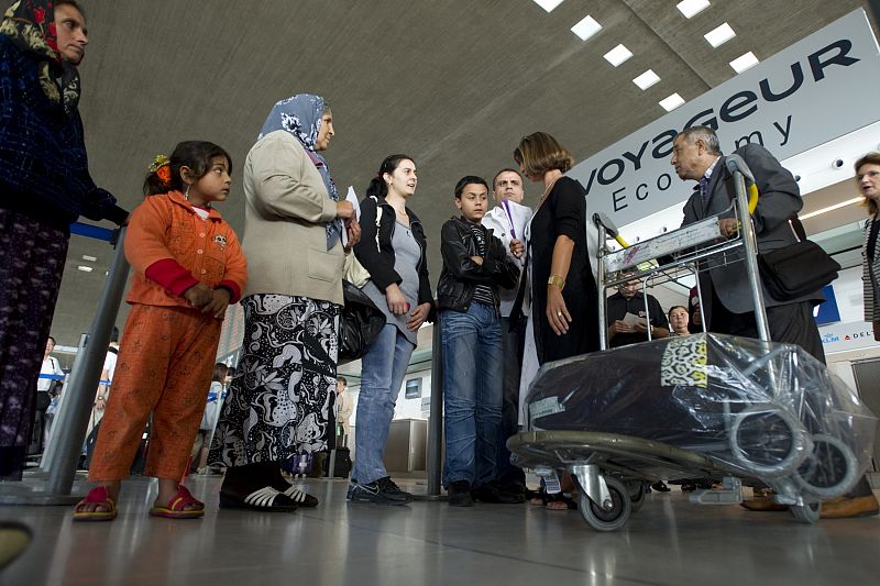 An woman from the French Office of Immigration and Integration (OFII) speaks with a Roma family at Charles-de-Gaulle airport at Roissy