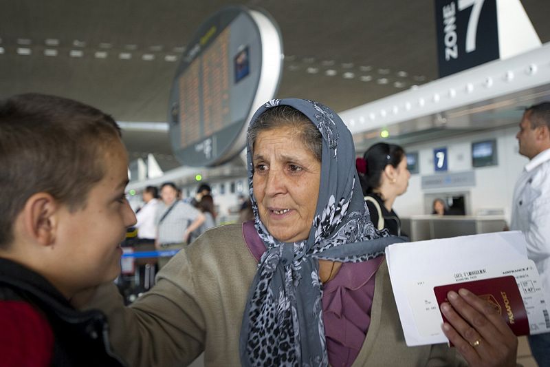 A Roma woman named Georgineta holds her passport and boarding pass at Roissy Charles-de-Gaulle airport near Paris