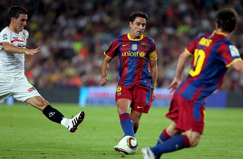 Xavi Hernández dando un pase para el delantero argentino Lionel Messi.