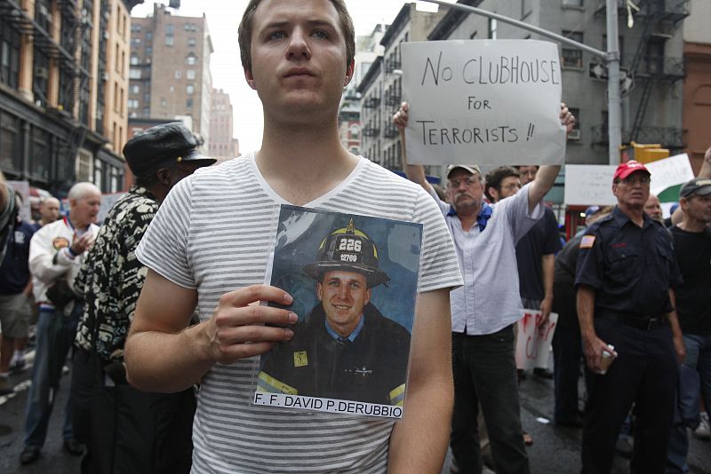 Un joven sujeta una fotografía de su tío, uno de los bomberos fallecidos en el World Trade Center el 11 de septiembre de 2001, durante una marcha en contra de la construcción de la mezquita en la zona.