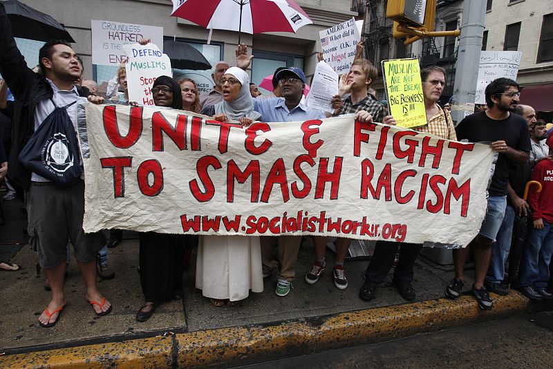 Varios jóvenes sostienen una pancarta contra el racismo.