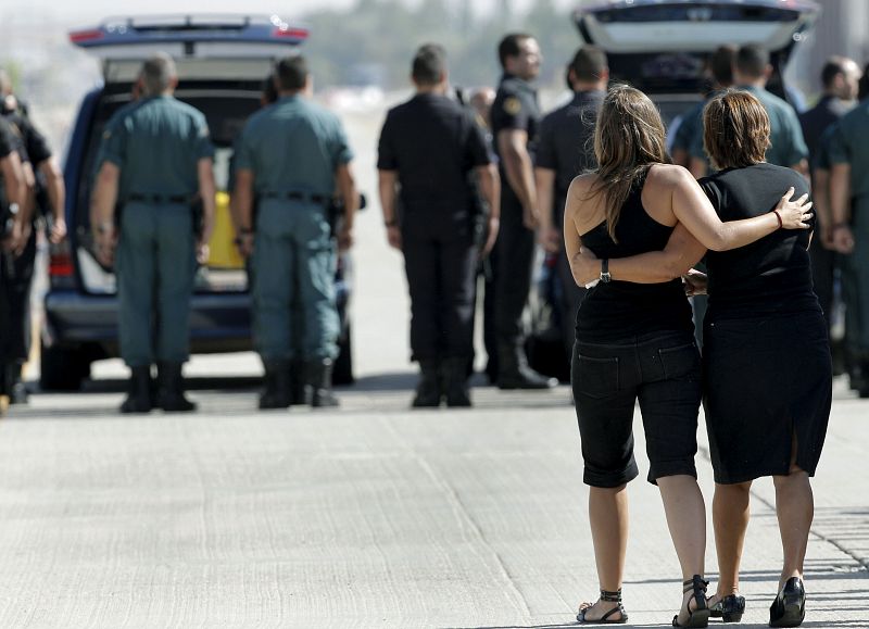 Los familiares de los fallecidos se abrazan durante el traslado de los féretros en la base aérea de Torrejón de Ardoz.