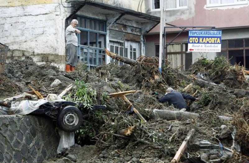 Dos vecinos buscan algunas de sus pertenencias entre las ruinas. 