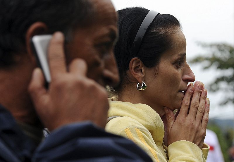 Relatives look at a body lying on the ground in Devinska Nova Ves district of Bratislava