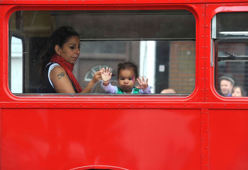 Una niña realiza muecas desde un autobús del tradicional carnaval de Notting Hill