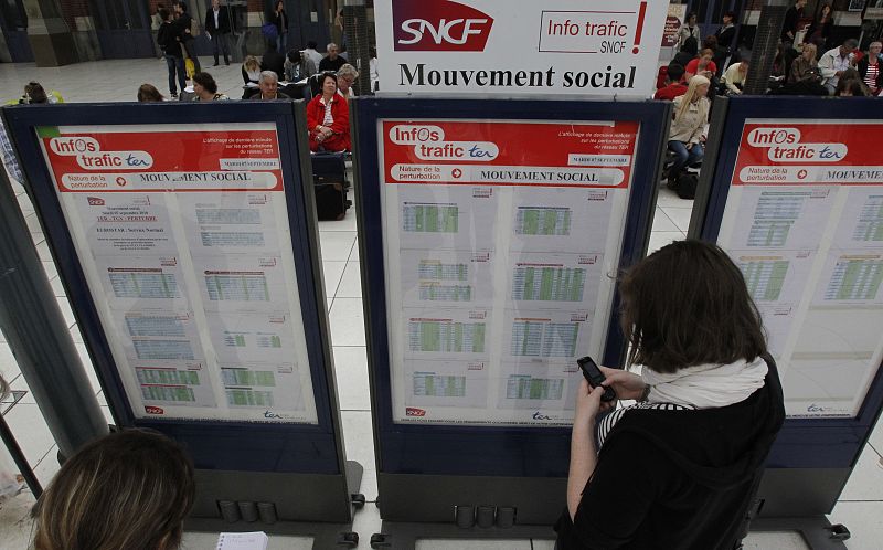 Commuters check a train schedule few hours before a strike at the Lille-Flandres station