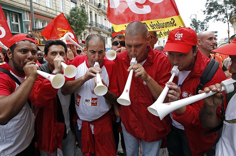 Private and public sector workers blow vuvuzelas as they demonstrate over pension reforms in Marseille