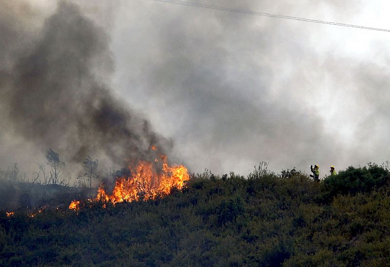 Dos bomberos, ante uno de los focos del incendio forestal del término municipal de Ontinyent