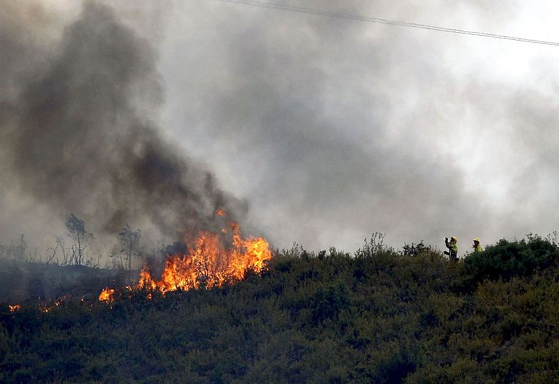 Dos bomberos, ante uno de los focos del incendio forestal del término municipal de Ontinyent