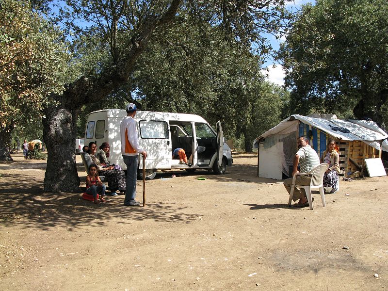 Un grupo de rumanos descansan sentados en corro en el campamento