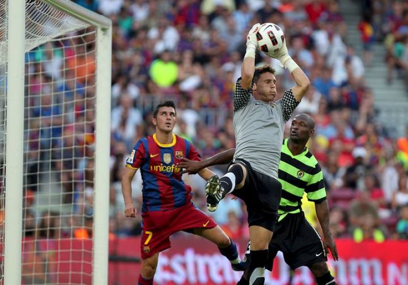 El guardamete del Hércules, Juan Calatayud, bloquea el balón ante la presencia de David Villa.