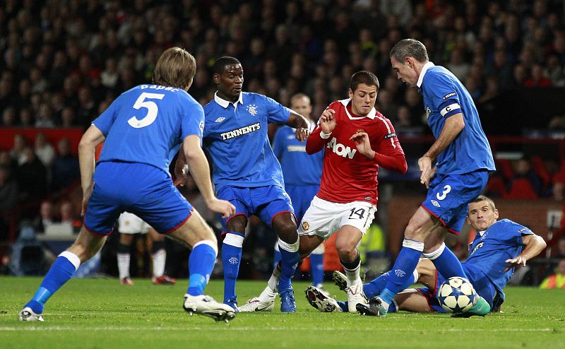 El delantero mexicano del Manchester United 'Chicharito' Hernández intenta avanzar entre la defensa del Rangers, en el 0-0 en que acabó el partido en Old Trafford.