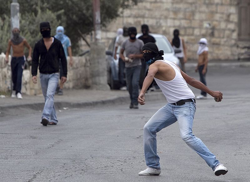 Un palestino sigue tirando piedras contra la policía israelí