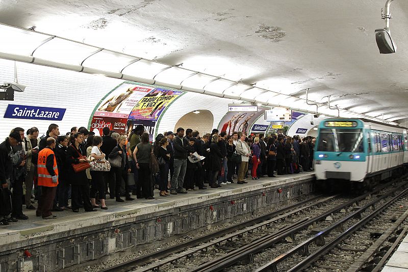 Commuters wait for a metro at the Gare Saint Lazare metro station in Paris