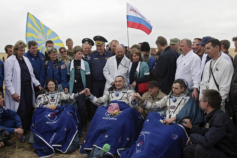 U.S. astronaut Dyson, Russian cosmonauts Skvortsov and Kornienko sit in chairs after they landed near the town of Arkalyk