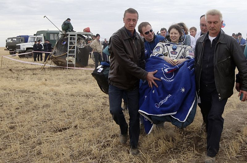 Specialists carry U.S. astronaut Tracy Caldwell Dyson after her landing near the town of Arkalyk