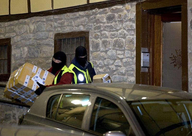 Miembros de la Policía trasladan el material incautado en la vivienda de uno de los detenidos en Vitoria