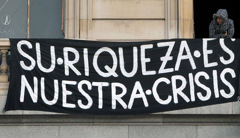 Un cartel anticapitalista en un edificio del centro de Barcelona, durante la jornada de huelga general convocada por las centrales sindicales mayoritarias, CCOO y UGT.