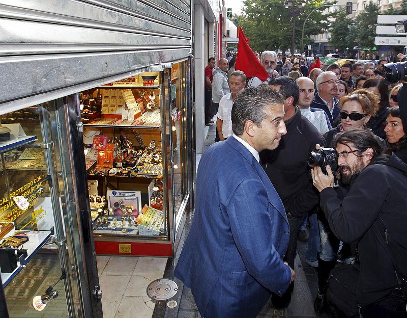 El propietario de un negocio cierra su comercio ante la presión de un piquete durante la jornada de huelga general en Santander.