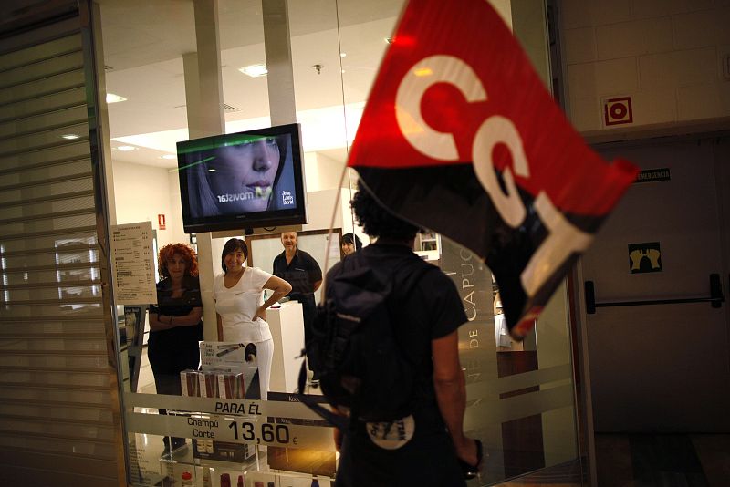 Un miembro de un piquete permanece frente a una tienda cerrada en Málaga.