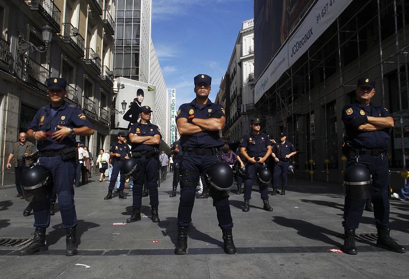 Agentes del Cuerpo Nacional de Policía guardan la entrada a la comercial calle de Preciados, en Madrid, durante la huelga general.