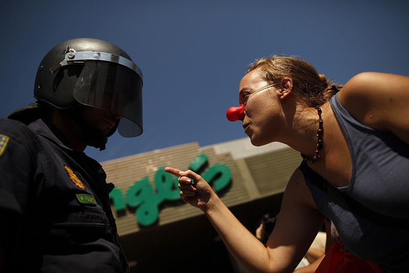 Una mujer, miembro de un piquete en Málaga, grita consignas sindicalistas a la policía antidisturbios en la entrada del Corte Inglés.