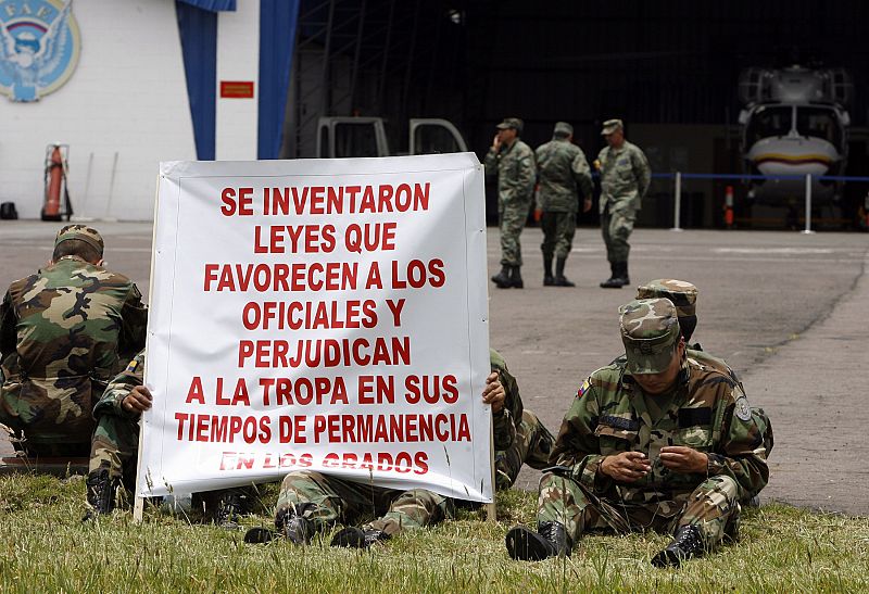 Soldados ecuatorianos portan una pancarta con sus reivindicaciones en el aeropuerto de Quito