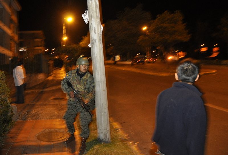 Un soldado del ejército toma posición durante los enfrentamientos con la policía en las afueras del hospital de Quito, donde el presidente de Ecuador, Rafael Correa, estaba encerrado.