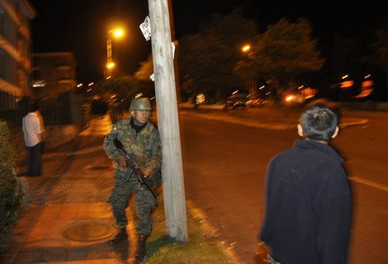 Un soldado del ejército toma posición durante los enfrentamientos con la policía en las afueras del hospital de Quito, donde el presidente de Ecuador, Rafael Correa, estaba encerrado.