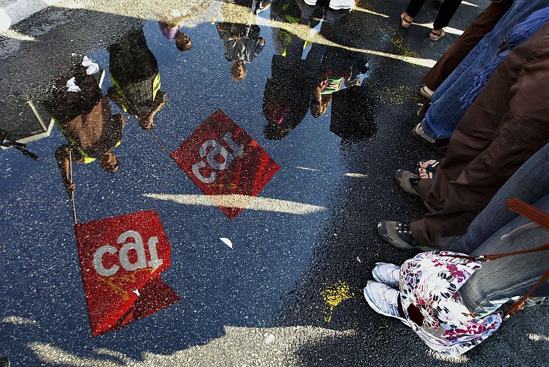 Demonstrators waving union flags are reflected in a puddle during a march in Nice