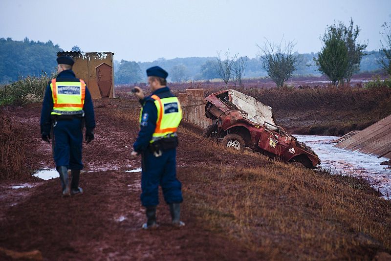 Policías húngaros inspeccionan la zona en la que se ha producido la rotura del dique de "barro rojo"