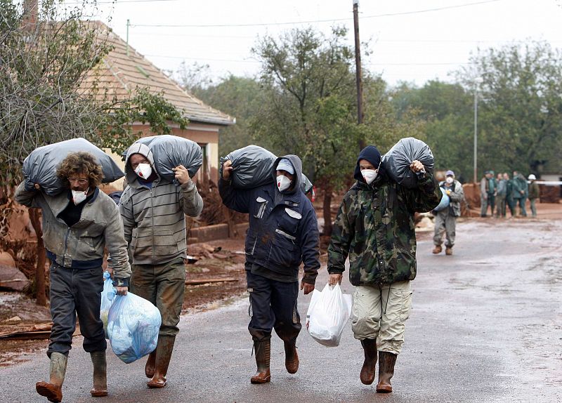 Locals leave their homes in the flooded village of Kolontar