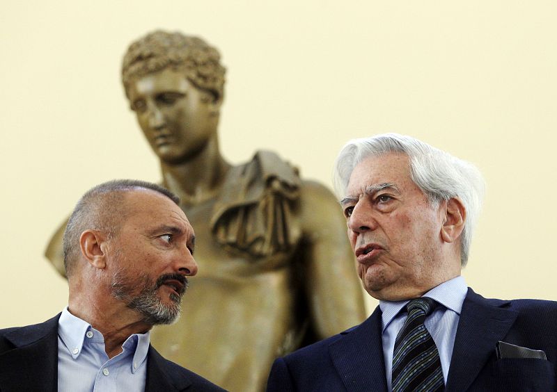 Spanish writer Perez-Reverte and Peruvian writer Mario Vargas Llosa talk while they pose for photographers before the media presentation of their books for children in Madrid