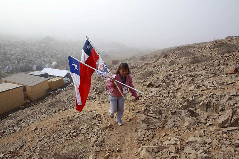 A relative of the 33 miners trapped deep underground in a copper and gold mine walks up a hill to celebrate after the T 130 drilling machine completed an escape hole for the 33 miners