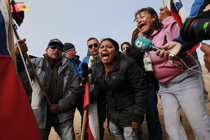 Relatives shout slogans after the T 130 drilling machine completed an escape hole for the miners at San Jose mine near Copaipo city