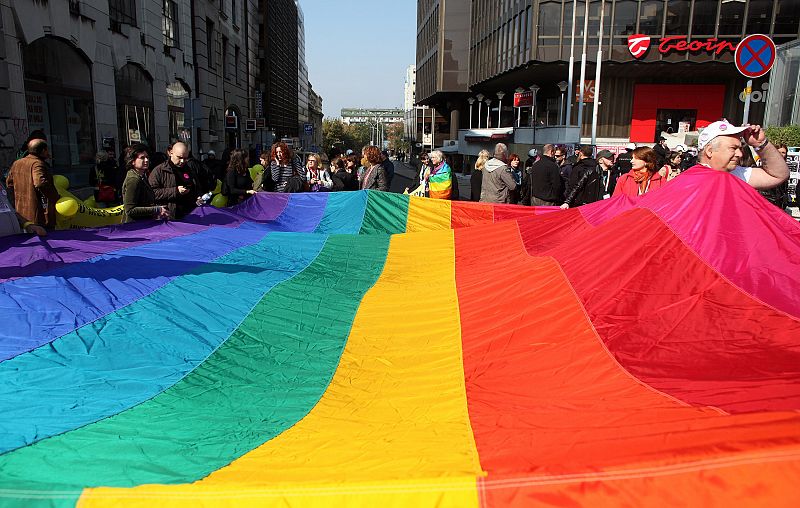 Gay rights activists hold rainbow flag during a rally in Belgrade
