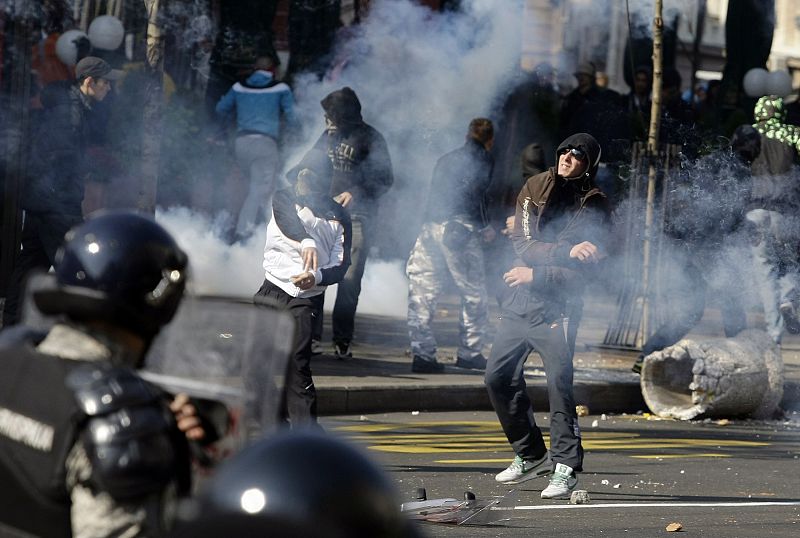 Anti-gay protesters throw stones towards riot policemen during clashes in Belgrade