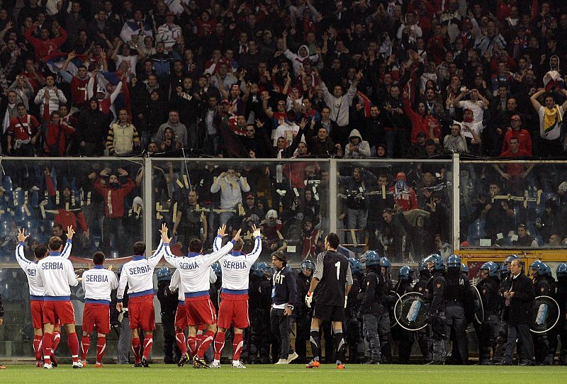 Los jugadores de Serbia piden a los ultras que se tranquilicen.