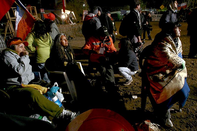 Familiares de los mineros observan en una pantalla las labores de rescate cerca del yacimiento San José, en Chile