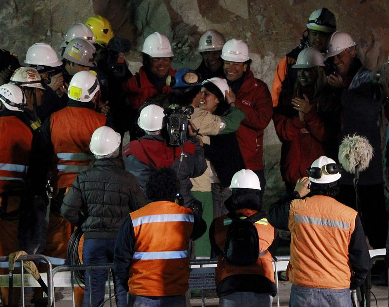 El minero Osman Araya, el sexto en salir, abraza a su mujer tras ser rescatado de la mina San José, donde ha permanecido más de dos meses atrapado a 700 metros bajo tierra.