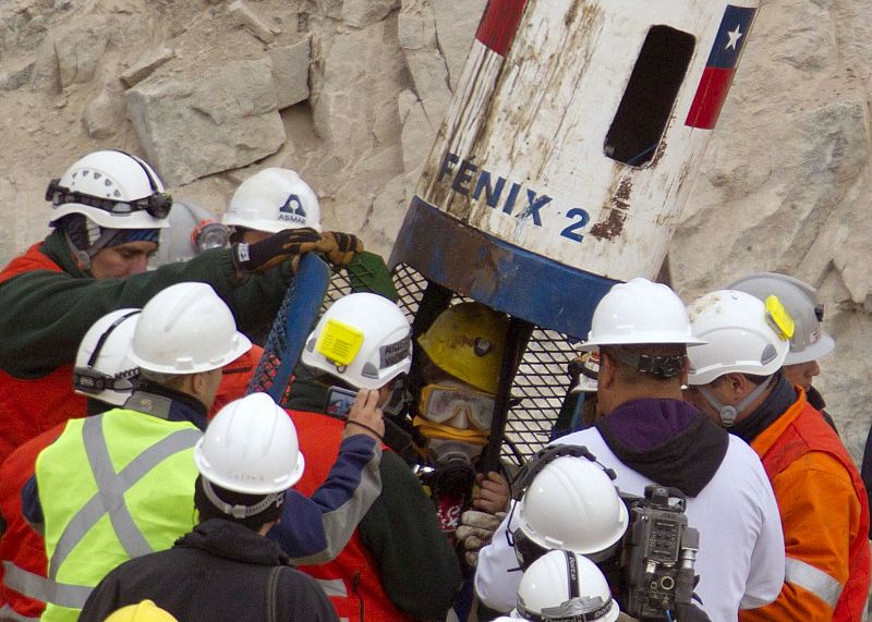 El minero Mario Gómez, de 63 años, llega a la superficie dentro de la cápsula Fénix en el noveno viaje de rescate que hace a las entrañas de la mina San José.