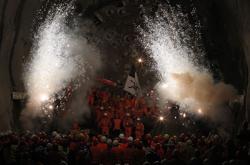 Los trabajadores celebran el momento en el que la máquina de perforación "Sissi" rompió la última sección del túnel de San Gotardo.