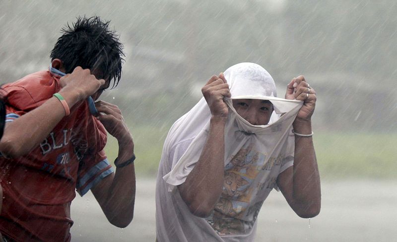 La población de Filipinas intenta protegerse como puede de la lluvia