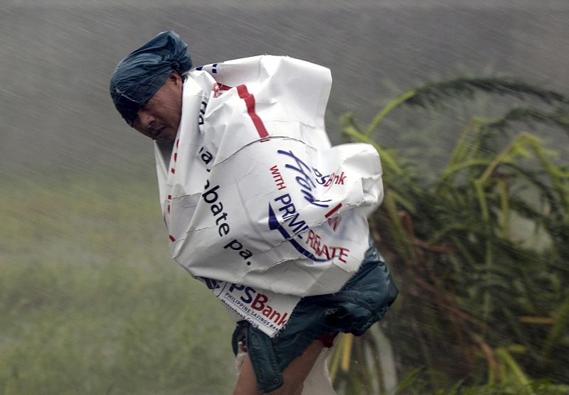 Un campesino lucha contra la fuerza del viento del Tifón 'Megi', que ha impactado de lleno en el norte de Filipinas