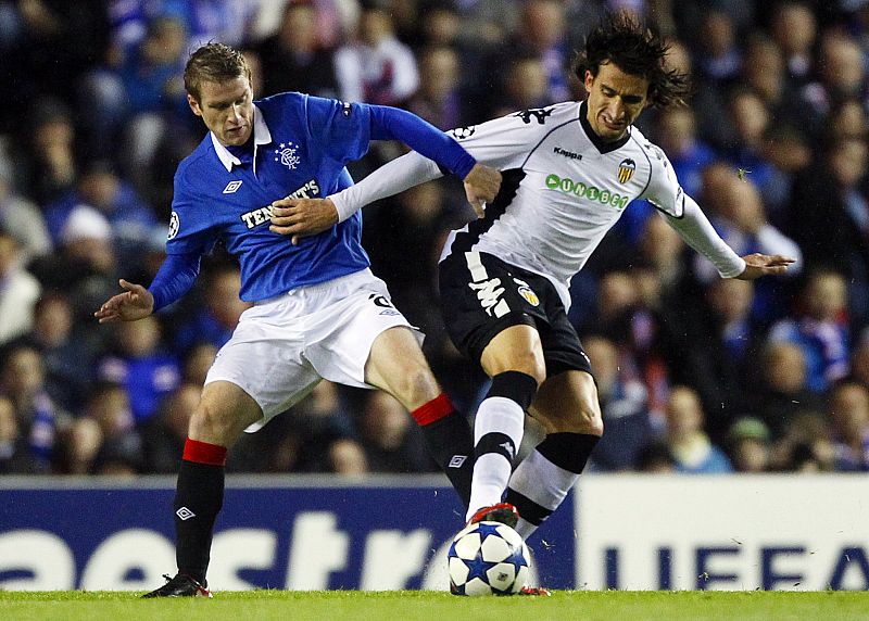 El jugador valencianista Mehmet Topal esconde el esférico ante la presión de Steven Davis del Rangers.